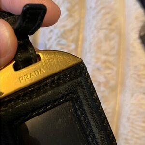 Authentic Prada luggage tag black leather gold hardware gently used.